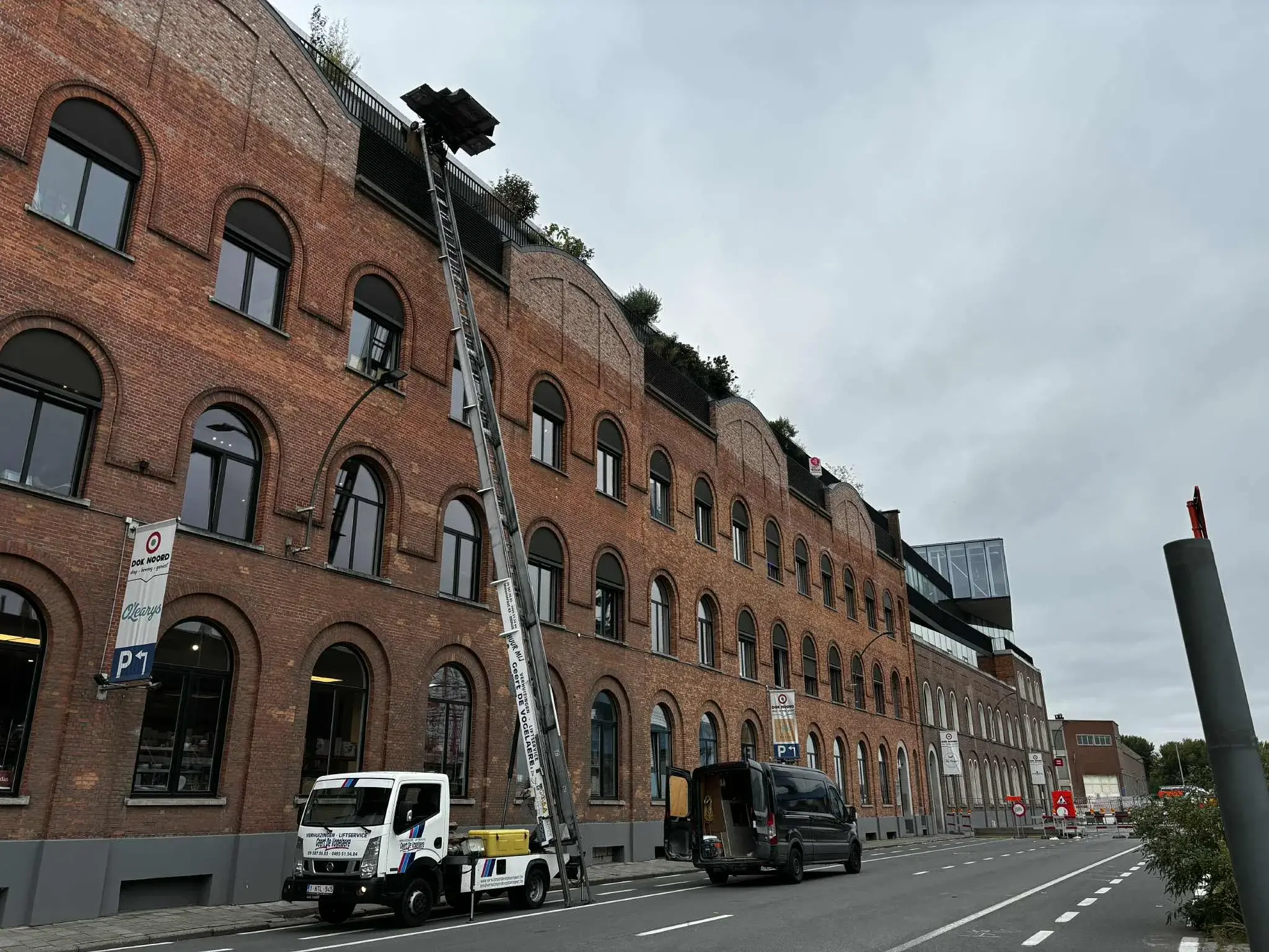 Verhuislift van De Vogelaere uitgeschoven tot het dak van een pakhuis