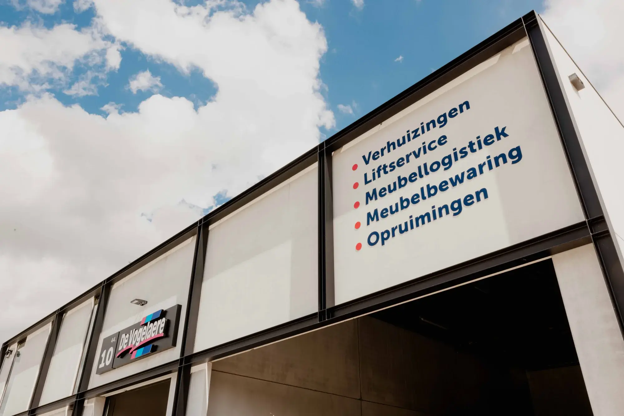 Gevel van Verhuizingen De Vogelaere in Deinze met het overzicht van de diensten