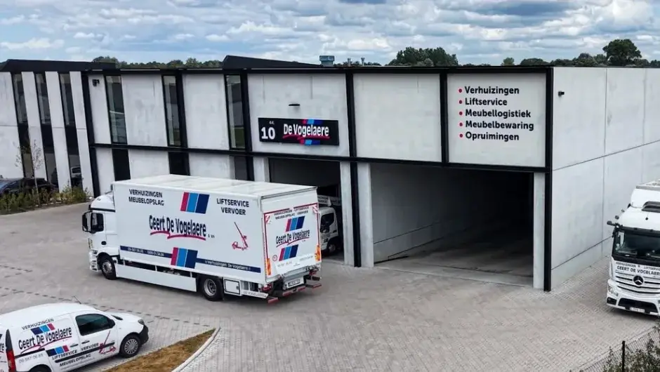 Het nieuwe magazijn aan de Filliersdreef in Deinze met verhuiswagens voor de poort