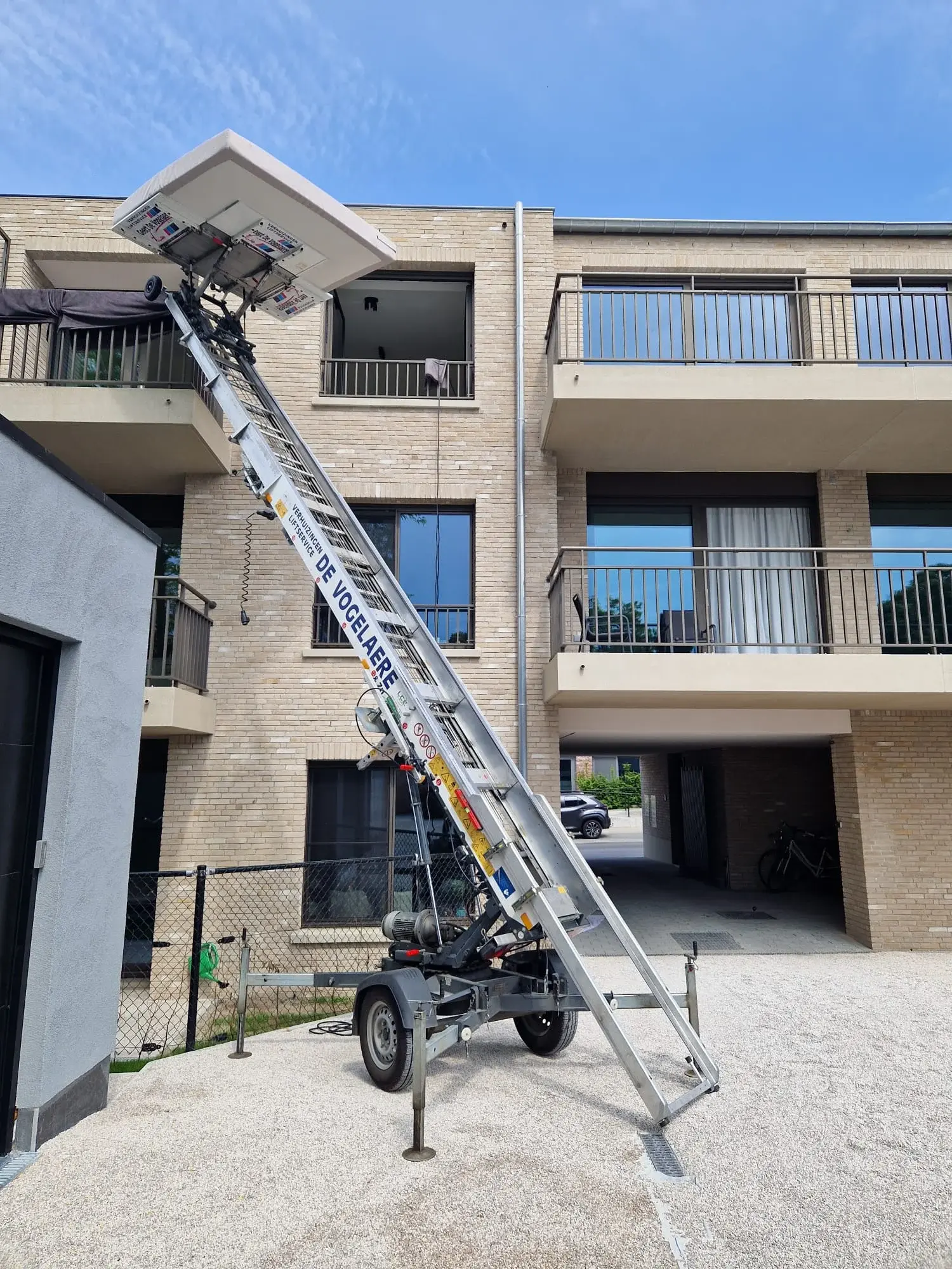 Verhuislift op aanhangwagen aan een appartement